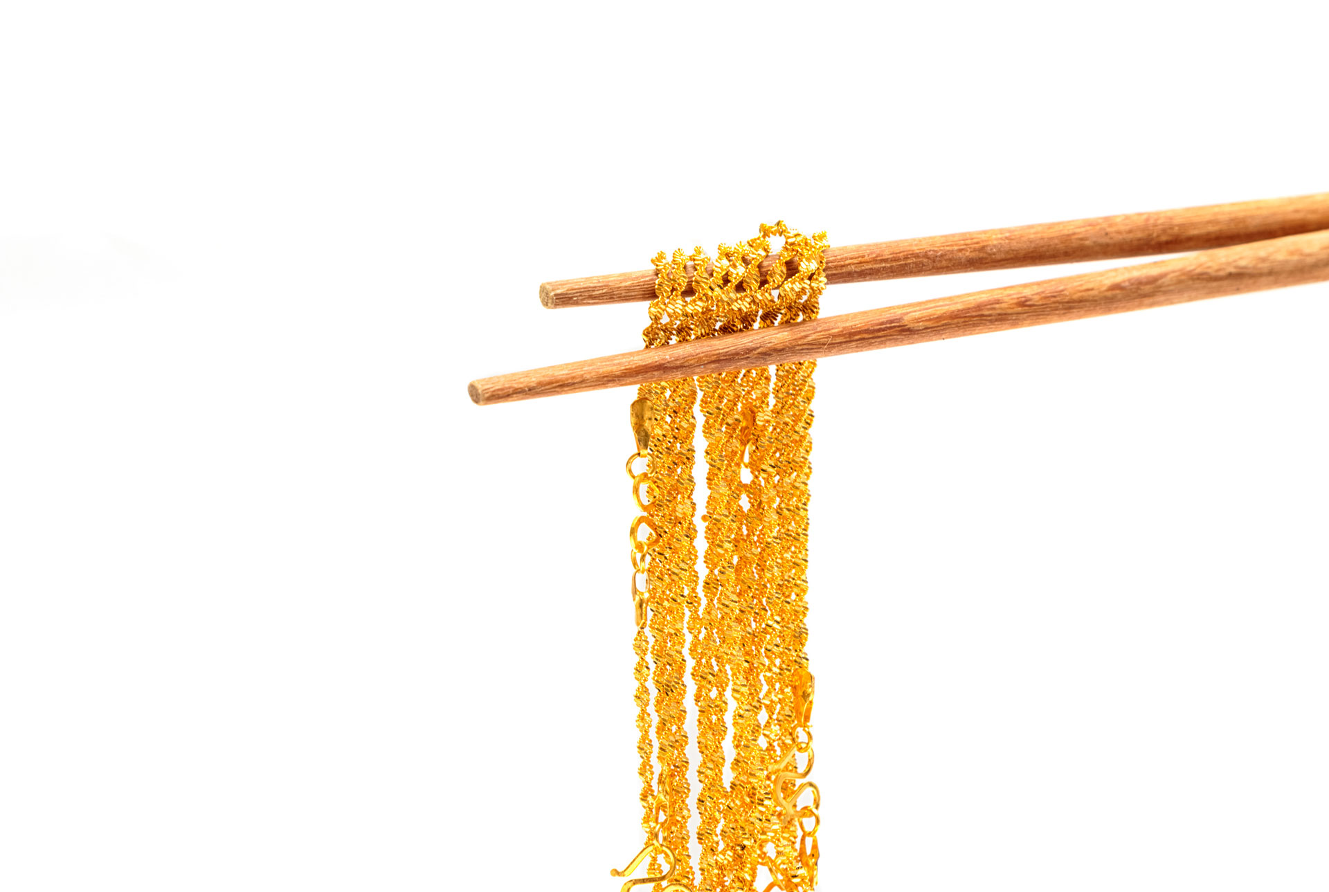 Gold necklace picked up with chopsticks