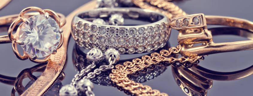 Can I Make Money by Selling Old Jewelry? - gold, silver, platinum, and diamond jewelry on dark grey background