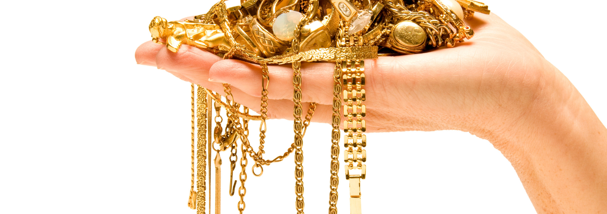 Selling Your Gold Jewelry: Here's What to Expect - hand holding a pile of gold jewelry