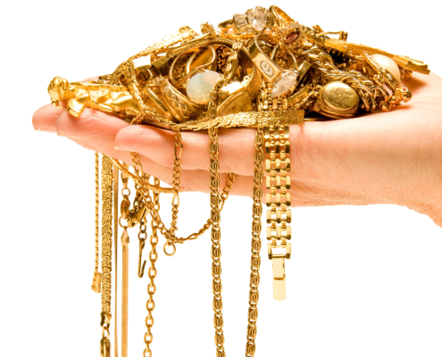 Selling Your Gold Jewelry: Here's What to Expect - hand holding a pile of gold jewelry