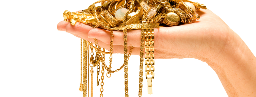 Selling Your Gold Jewelry: Here's What to Expect - hand holding a pile of gold jewelry