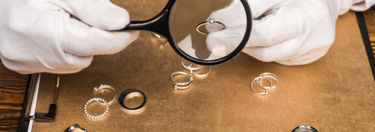 Why Can't I Sell My Diamond Ring for What I Paid for It? closeup of jewelry appraiser holding ring under magnifying glass