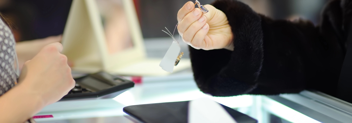 Woman choosing the perfect earrings at a jeweler, close up photo. Focus on your hands.