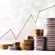 upward trending graph with gold and silver coins stacked below